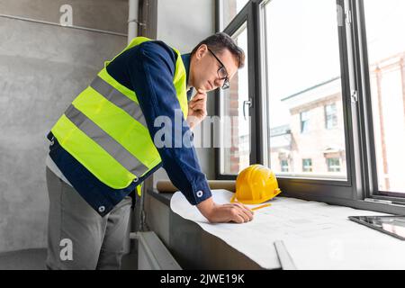 male architect with blueprint working at office Stock Photo