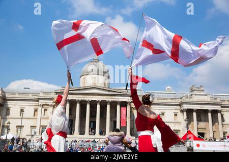 People watch acrobatic performances as they gather for St George’s Day celebrations in Trafalgar Square, central London. Stock Photo