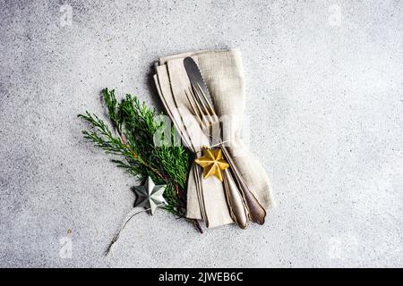 Overhead view of Christmas cutlery set with Christmas bauble decorations and thuja branches Stock Photo