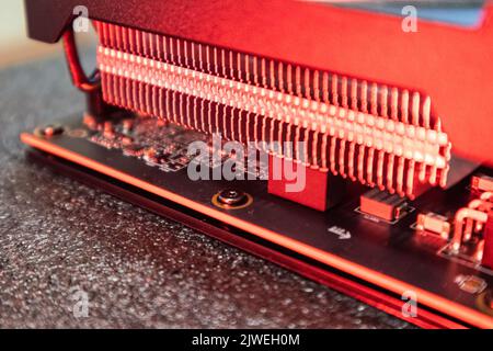 Gpu graphics or video card cooling system close-up in red light, PC hardware electronics details for gamer or crypto mining, components from powerful Stock Photo