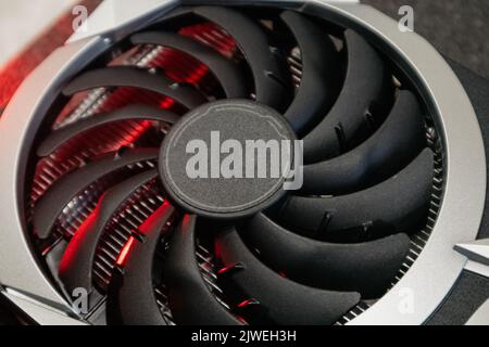 Cooler fan on Gpu graphics video card, close-up in red light with selective focus, PC hardware details. Components from computer for gaming or crypto Stock Photo