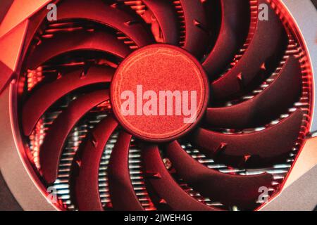 Cooler fan on Gpu graphics video card, close-up in vivid red light, PC hardware details. Components from computer cooling system Stock Photo