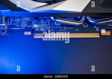 Gpu graphics or video card electrical contacts panel on a chip close-up in blue light, PC hardware electronics details, components from powerful compu Stock Photo