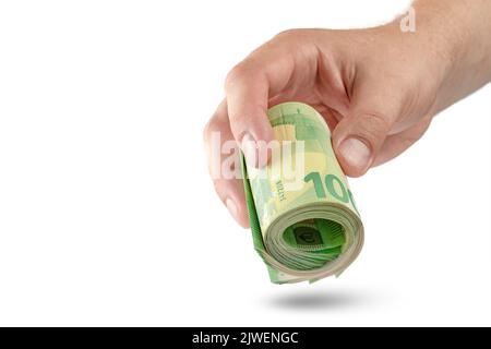 Money in hand isolate on white. The hand holds a roll of 100 euro banknotes. Euro banknotes rolled up in hand isolated on white background. The Stock Photo