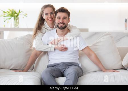 Couple relaxing in living room and smiling Stock Photo
