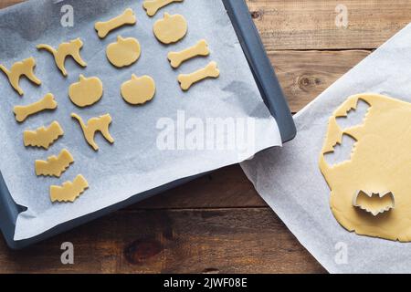 Cookies in various shapes for Halloween on a baking sheet. Cookies cut before baking. Copy space. Stock Photo