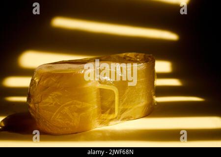 yellow plastic cup covered with transparent plastic Stock Photo