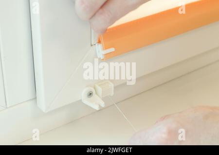 Assembly of roller blinds. Hands are assembling roller blinds, close-up Stock Photo