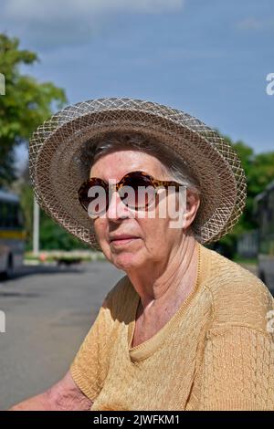 Senior old woman sunbathing on the street Stock Photo - Alamy