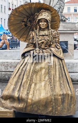 Unidentified busking mime in the retro costume with umbrella on street of Lviv, Ukraine Stock Photo