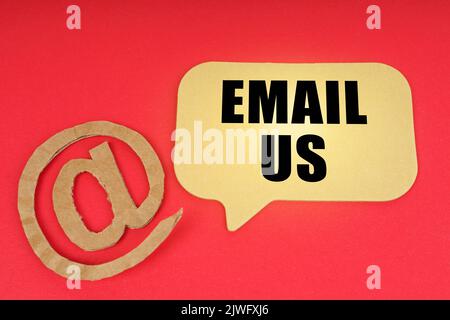Email and business. On a red surface, a symbol and a sign with the inscription - Email Us Stock Photo