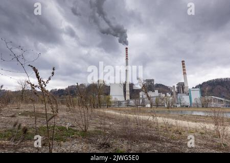 Thermal power plant burning coal with large cooling tower, emitting billowing polluted smoke into the atmosphere Stock Photo