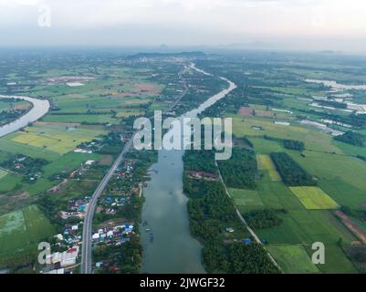 Top view of the Sakae Krang River, Uthai Thani Province where both sides of river are filled with lush green trees. There are community near waterside Stock Photo