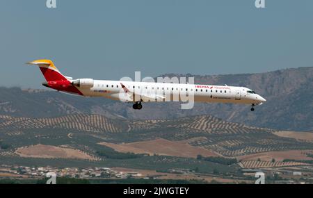 An Iberia Regional (Air Nostrum) Bombardier CRJ-1000 about to land at Granada/Jaén Federico García Lorca airport.The Bombardier CRJ700, CRJ900, and CRJ1000 are a family of regional jet airliners that were designed and manufactured by Canadian transportation conglomerate Bombardier (formerly Canadair) between 1999 and 2020. The CRJ program was acquired by Japanese corporation Mitsubishi Heavy Industries in 2020, which ended production of the aircraft. Stock Photo