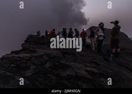 AFAR, ETHIOPIA - MARCH 26, 2019: Tourists at the edge of Erta Ale volcano crater in Afar depression, Ethiopia Stock Photo