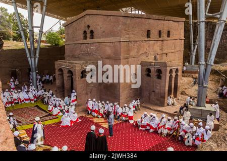 LALIBELA, ETHIOPIA - MARCH 29, 2019: Christian priests in front of Bet Maryam, rock-cut church in Lalibela, Ethiopia Stock Photo