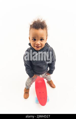 full shot of an Afro-American boy with a skateboard, studio shot vertical isolated. High quality photo Stock Photo