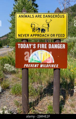 Yellowstone National Park warning signs about the danger level of wildfires and never approach or feed wildlife. Stock Photo