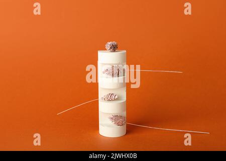 Empty showcase pedestal and floral decor on color background Stock Photo