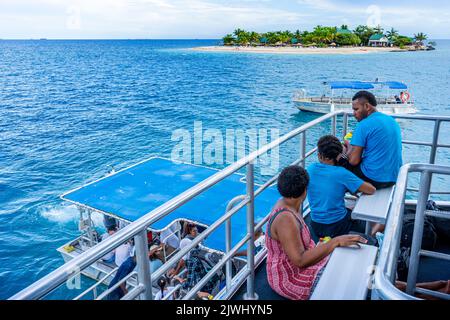 Small boats transporting tourists from Yasawa Flyer Island Ferry to Beachcomber Resort, Yasawa Islands Fiji Stock Photo