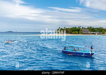 Small boats transporting tourists from Yasawa Flyer Island Ferry to Beachcomber Resort, Yasawa Islands Fiji Stock Photo