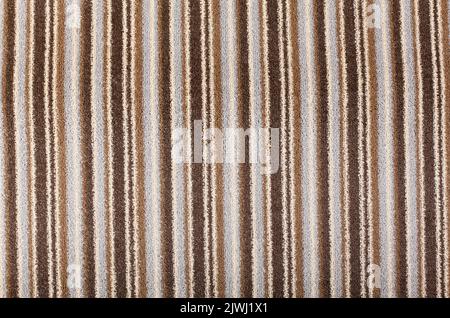 A brown, beige striped carpet background. A brown and beige striped carpet texture. Stock Photo