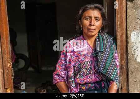 Portrait of a Mayan woman in traditional clothing standing in the doorway of her shack. Nahuala, Solola, Western Highlands, Guatemala, Central America. © Kraig Lieb Stock Photo