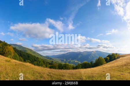 carpathian countryside landscape in evening light. beautiful mountain scenery in autumn. grassy meadows and forested hills. rural valley in the distan Stock Photo