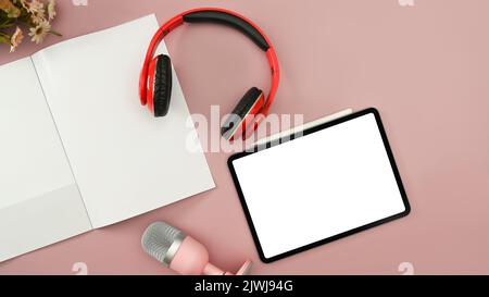 Flat lay digital tablet, wireless headphone and microphone on pink background. Radio, podcasts, blogging and technology concept Stock Photo