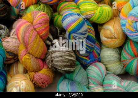 Close-up woolen threads multicolored in a basket, top view. Stock Photo