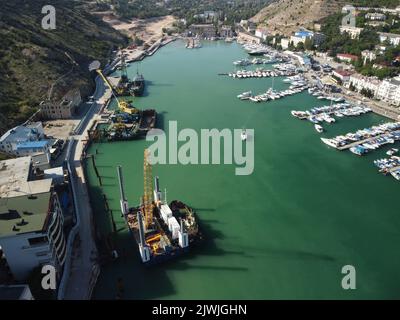 Floating crane dredging barges working on the construction of a marina. Aerial top view Stock Photo