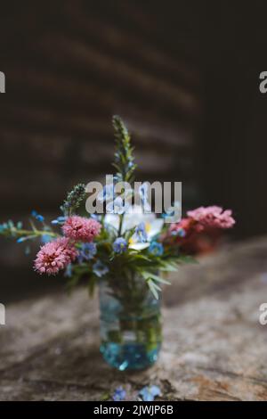 Wild flowers in vase on wooden table cozy interior rustic style decoration countryside home Stock Photo