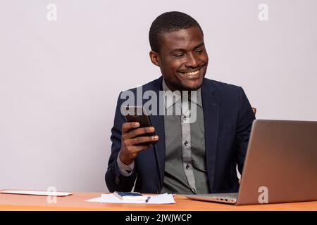 black businessman using his phone and laptop Stock Photo