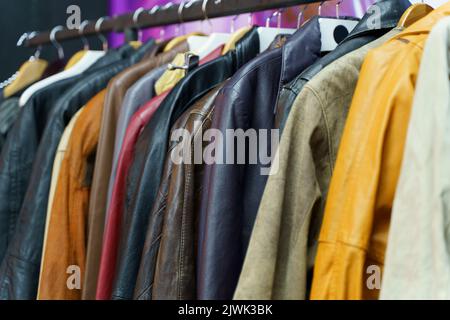 Second hand vintage clothes in a store on sale. Fashionable European used retro jeans, t-shirts, dresses, pants and accessories. Recycling and life extension for clothes concept. High quality photo Stock Photo