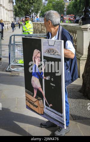 London, UK. 06th Sep, 2022. Sartirical artist and painter Kaya Mar looks towards Downing Street. He is with one of his works, depicting new Prime Minister Liz Truss entering 10 Downing Street arriving in a Poundshop box. Credit: Imageplotter/Alamy Live News Stock Photo