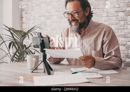 One man record content using a mobile phone do upload on video channel web page. Content creator people speaking and talking with cellular. Modern wor Stock Photo