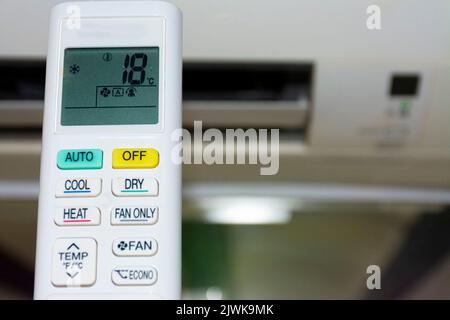 Remote control of air conditioning, marking low temperature. Defocused background. Waste of energy concept Stock Photo