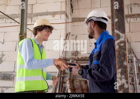 Team of young foreman and worker handshake with hands for teamwork for achievement, engineer and construction site, architect shaking hand for success Stock Photo
