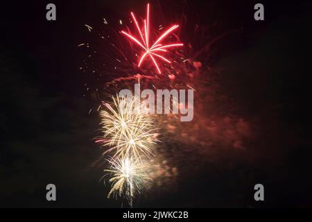 Aerial view of bright fireworks exploding with colorful lights against dark night sky on US Independence day holiday Stock Photo