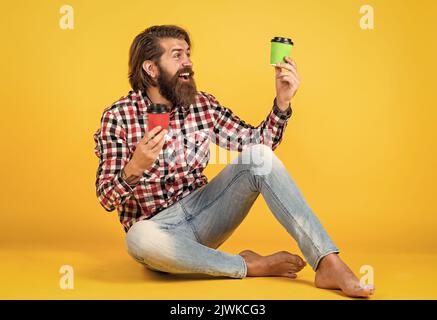 I like it. handsome bearded man holding a white cup. mug with beverage. drinking tea or coffee. good morning. morning vibes at home. concept of Stock Photo
