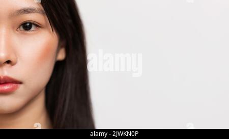 Half face portrait of korean lady with glow skin and natural makeup posing at camera, panorama, copy space Stock Photo