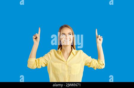 Young beautiful woman in shirt pointing index finger up for advertisement, recommending Stock Photo