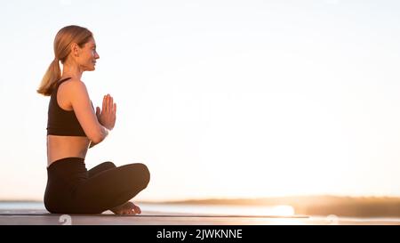 Sunset Meditation. Beautiful Calm Middle Aged Woman Meditating Outdoors Stock Photo