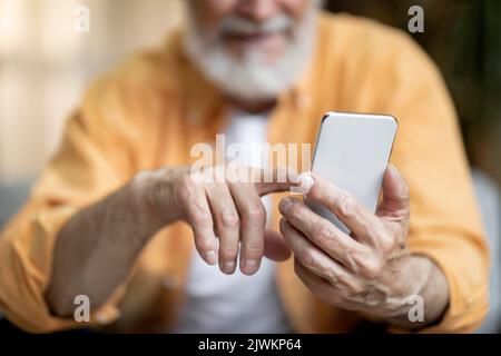 Cropped of senior man using smartphone at home Stock Photo