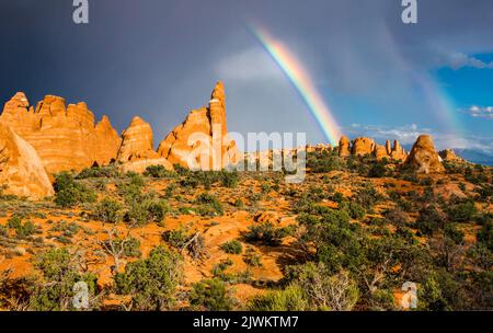 A partial rainbow with virga over Entrada sandstone fins in the Devil's Garden, Arches National Park, Moab, Utah. Stock Photo