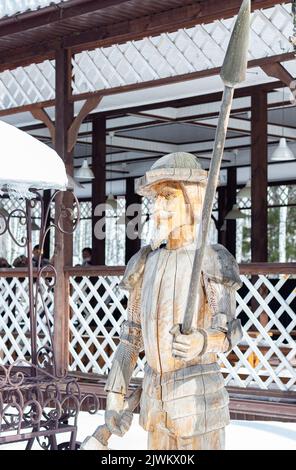 Wooden architecture. Proficiency with cleaver and saw. Creation of sculptures from wood. Wooden sculpture of Don Quixote, knight-errant. Siberian wood Stock Photo