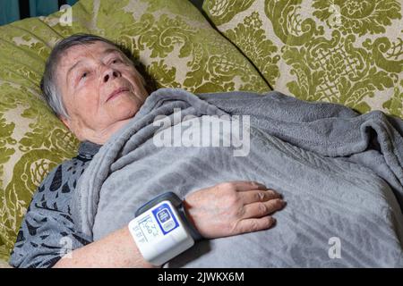 elderly woman measures her blood pressure with an electronic blood pressure monitor. Hypertension, High blood pressure in the elderly. Health old peop Stock Photo