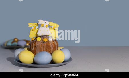 Easter cake decorated Colorful gingerbread bunnies with sugar icing and pastel blue and yellow Easter eggs. Easter traditions. Holiday concept with co Stock Photo
