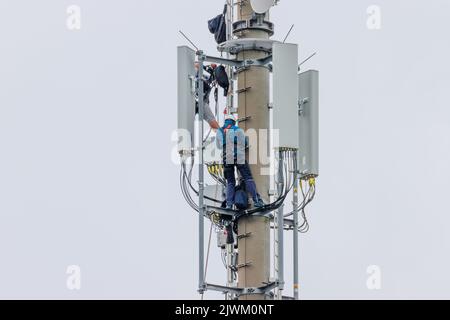 two Telekom technicians perform work on a transmission tower Stock Photo
