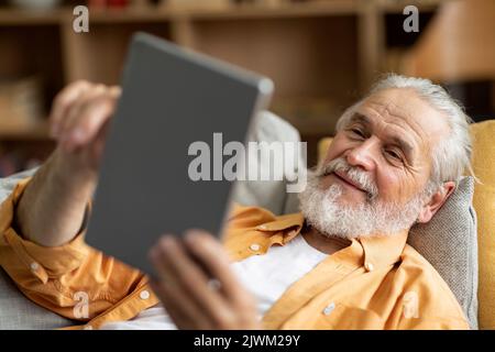 Cheerful senior man using digital tablet at home Stock Photo